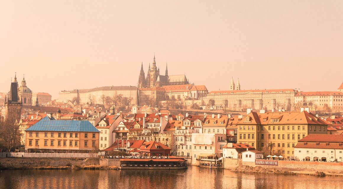 Photo of Prague Castle sitting above the Vltava river at sunset