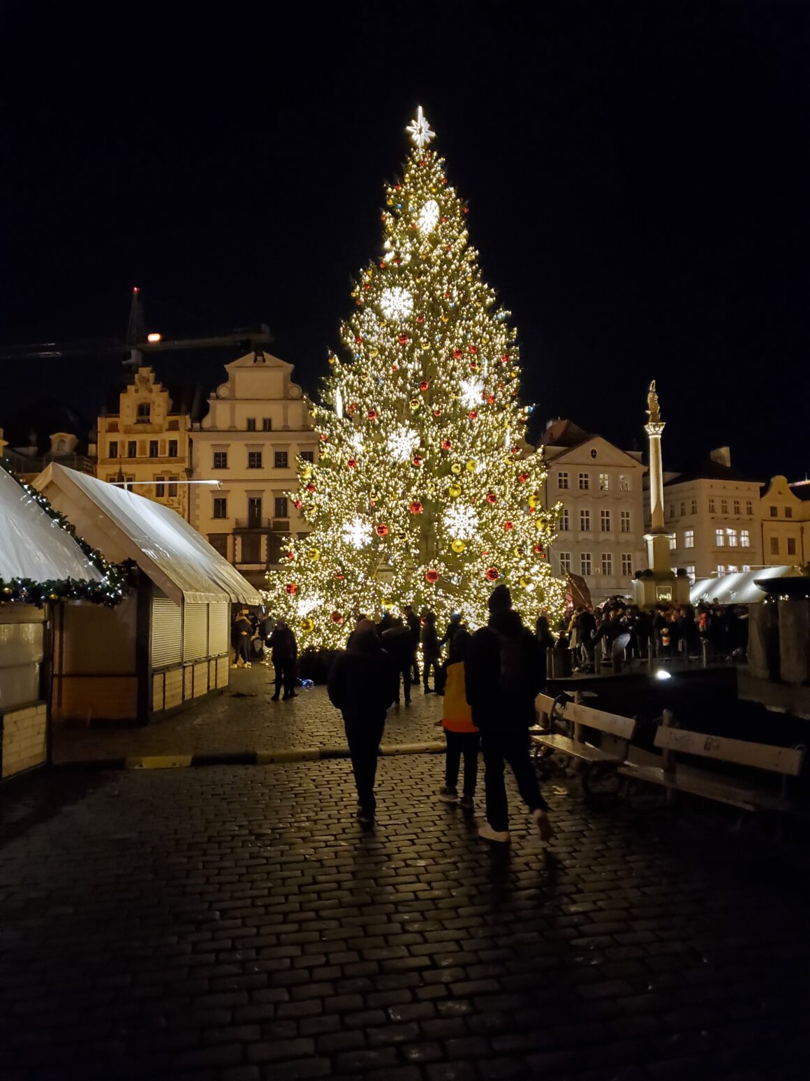 A Christmas tree surrounded by wooden stalls in Prague's old town square, one of the many Czech Christmas markets