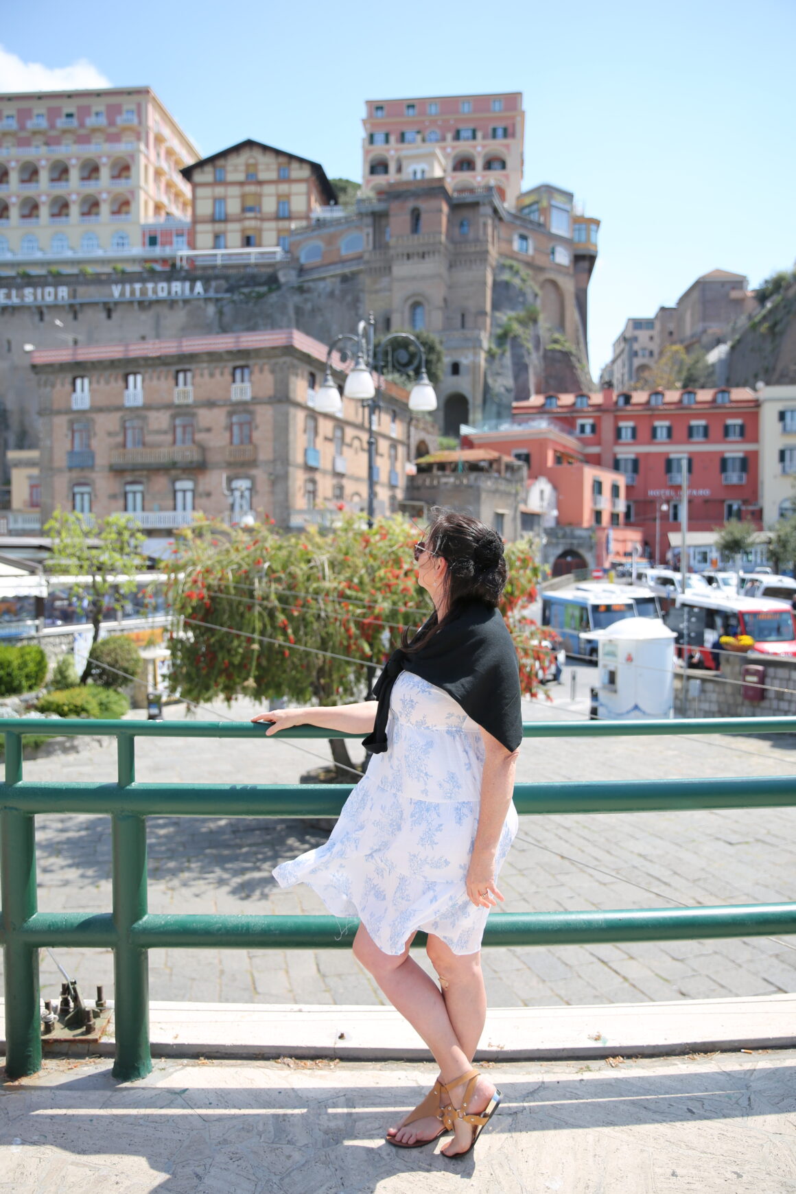 A woman stands in front of the backdrop of Sorrento on the Amalfi Coast