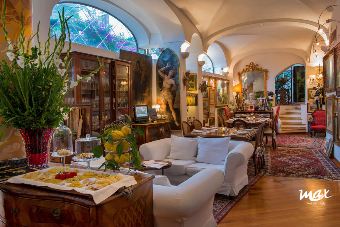 One of the best restaurants in Positano, Italy, Ristorante Max, has a beautiful interior with gallery walls and cozy chairs