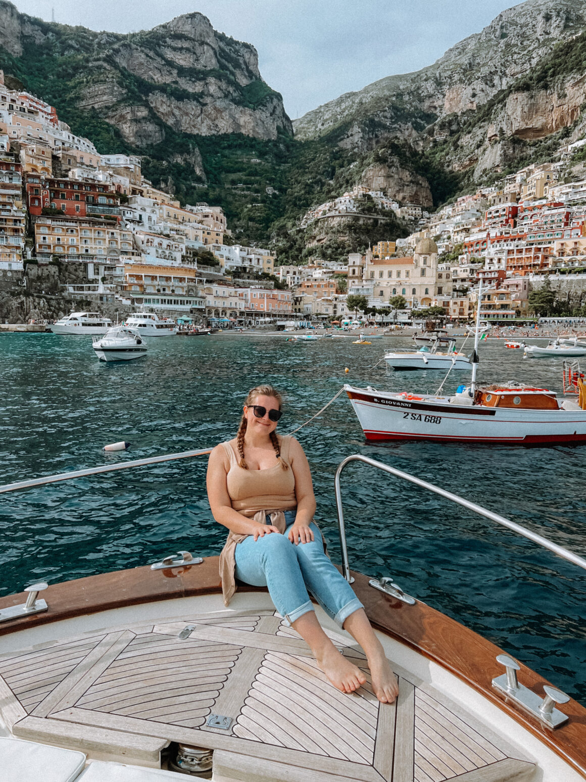 A girl poses on a boat off the coast of Positano one of the best things to do in Positano