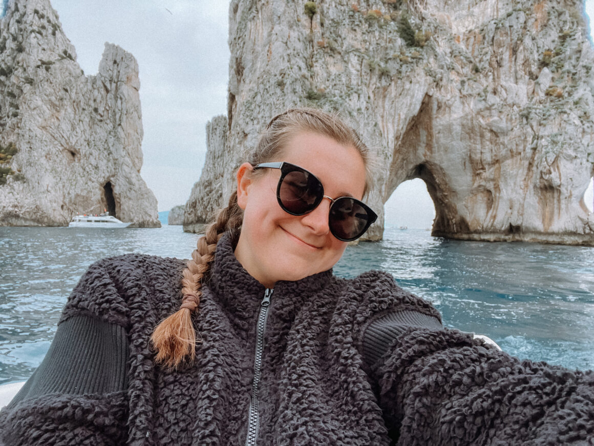 A woman on a boat in Capri on a day trip to the island, one of the best things to do in Positano