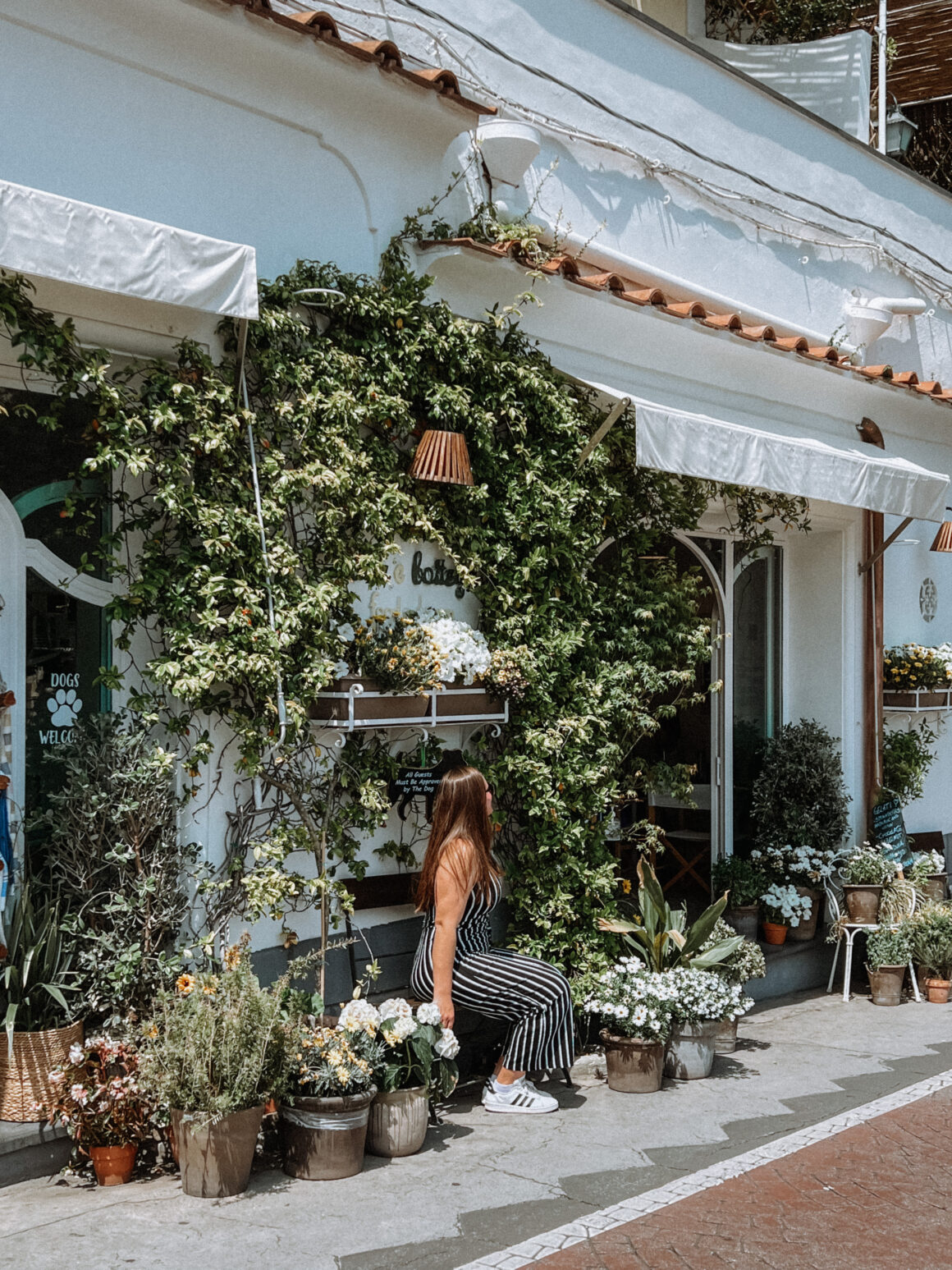 A woman sits at a store in Positano, one of the best things to do in Positano