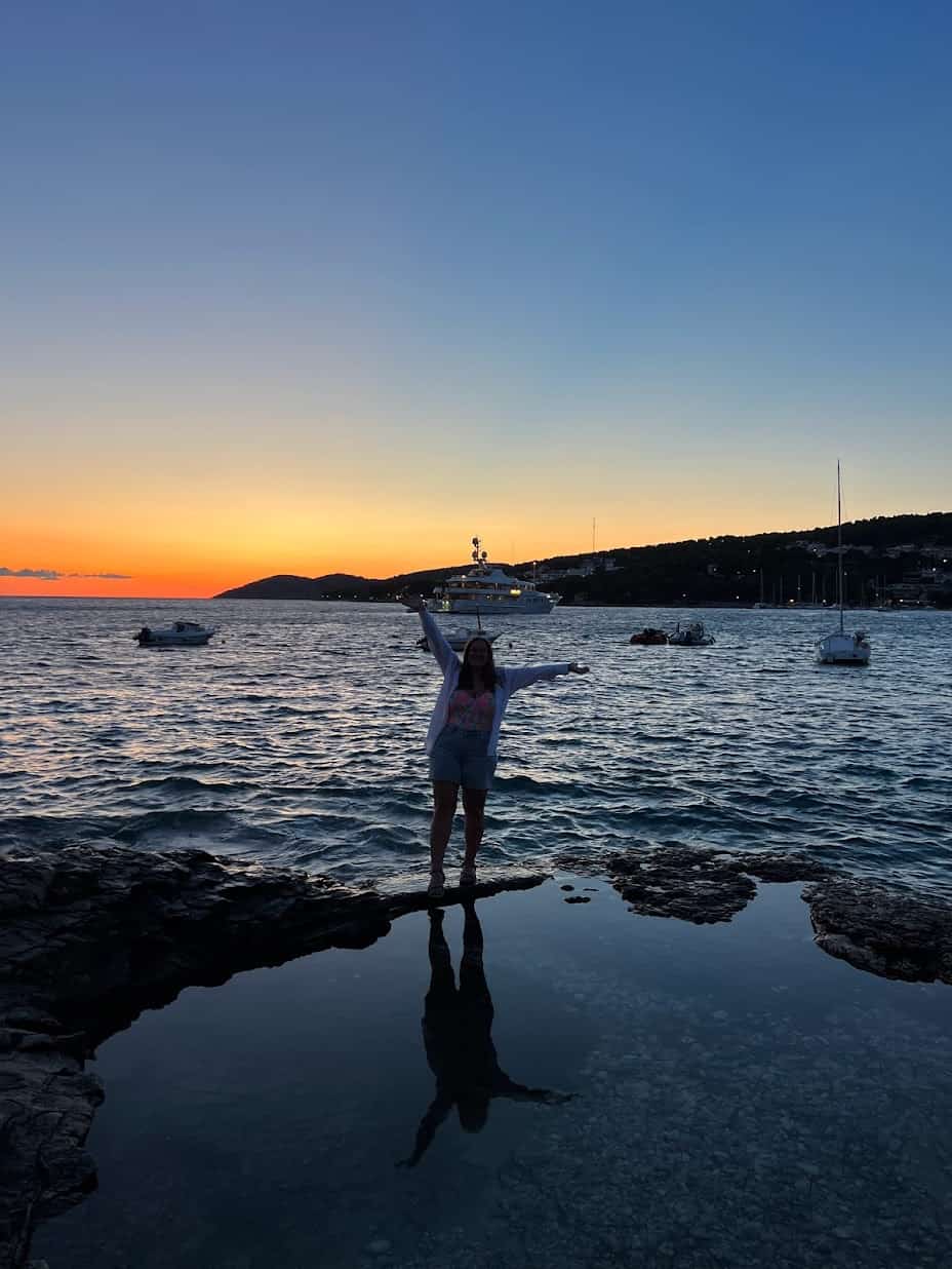 The silhouette of a girl walking along a tide pool during Yacht Week Croatia