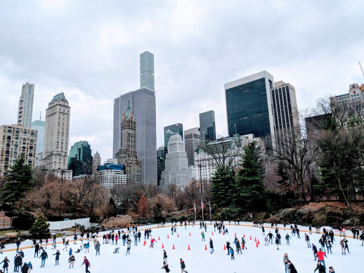 The ice rink in Central Park with the Manhattan skyline in the distance, one of the best free things to do in New York City.