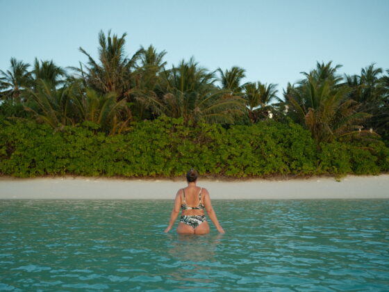 A girl walking in the water off one of the islands in the Maldives