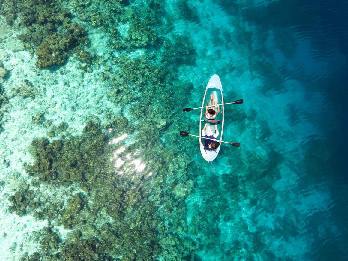 Two people kayak in the Maldives