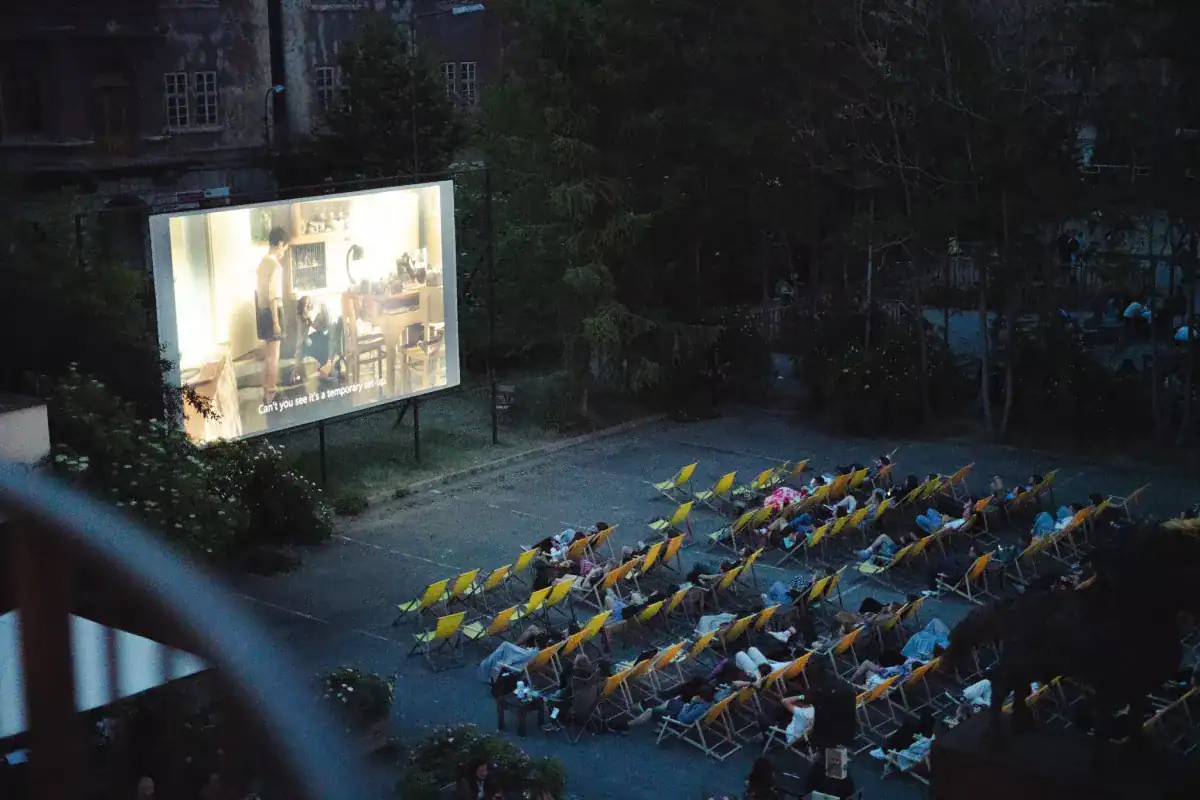 People sit in lawn chairs at an open air cinema at Kasarna Karlin, one of the most unusual things to do in Prague