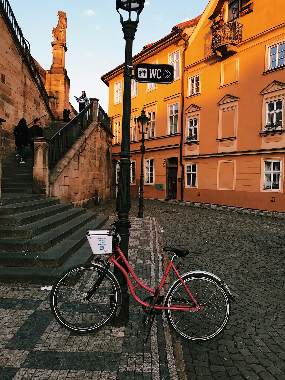 A bike stands against a lightpost in downtown Prague